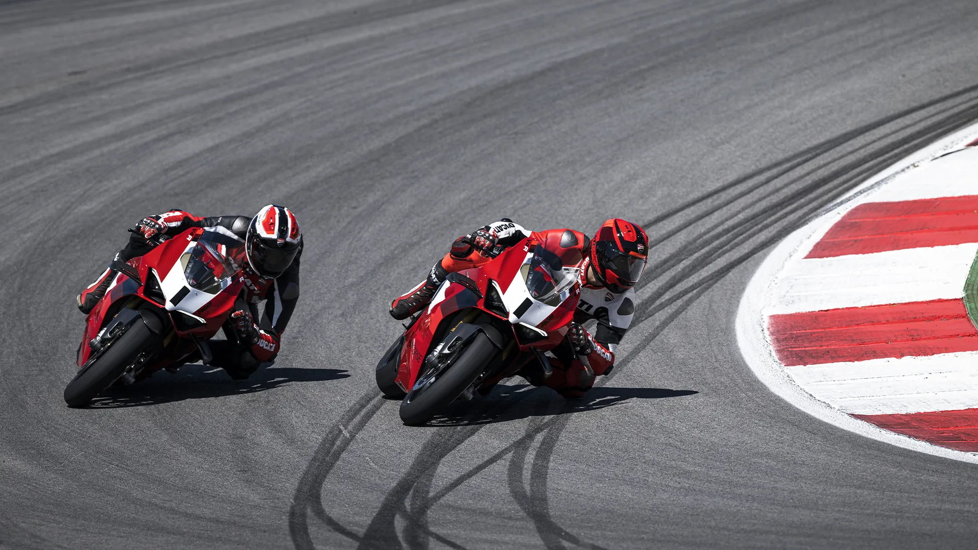 Ducati Panigale racing on track at Laguna Seca with riders leaning into a turn