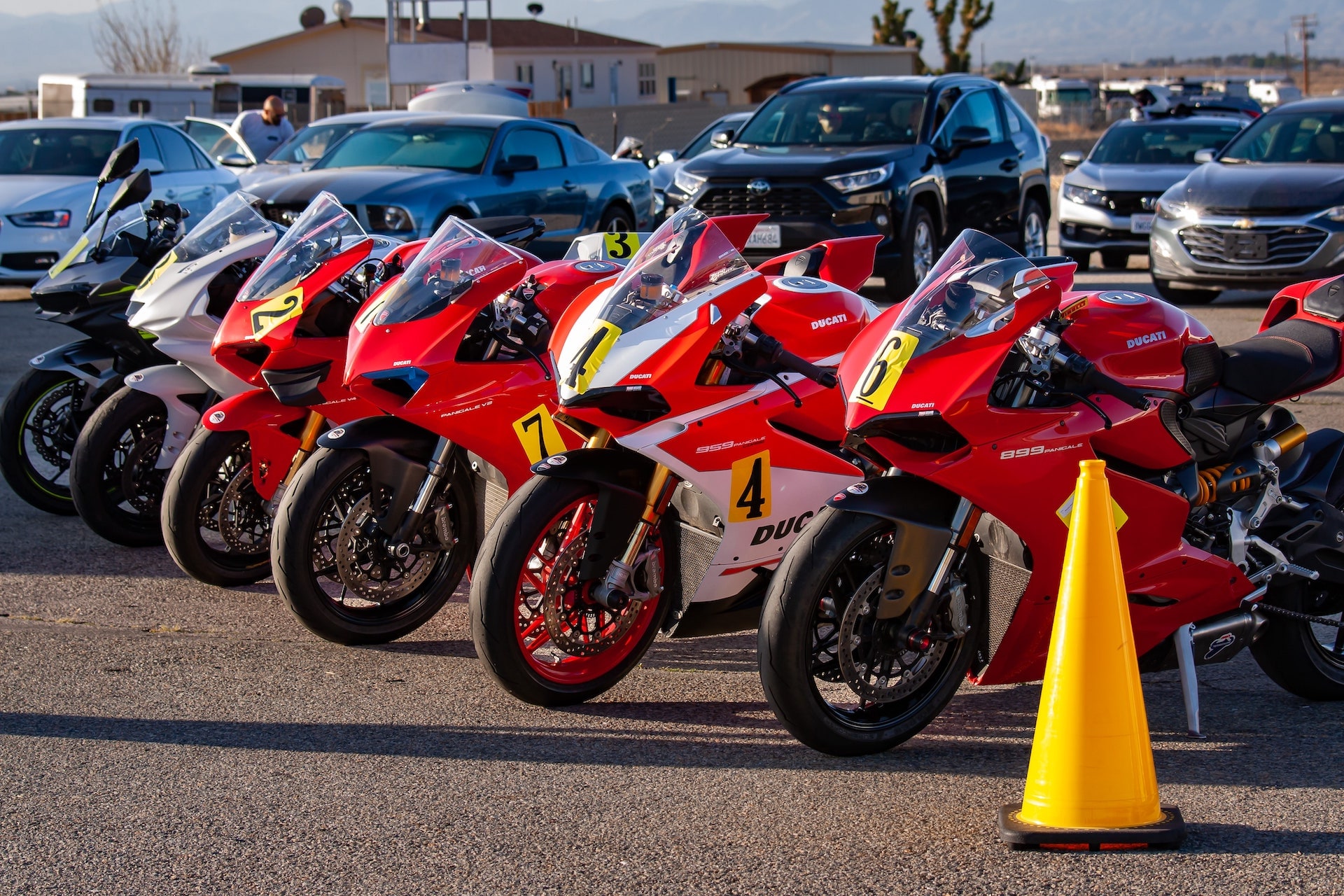 DROC track days at Streets of Willow 5 A row of red Ducati Panigales with race numbers lined up in the paddock at Streets of Willow, orange cone in front, April 2022