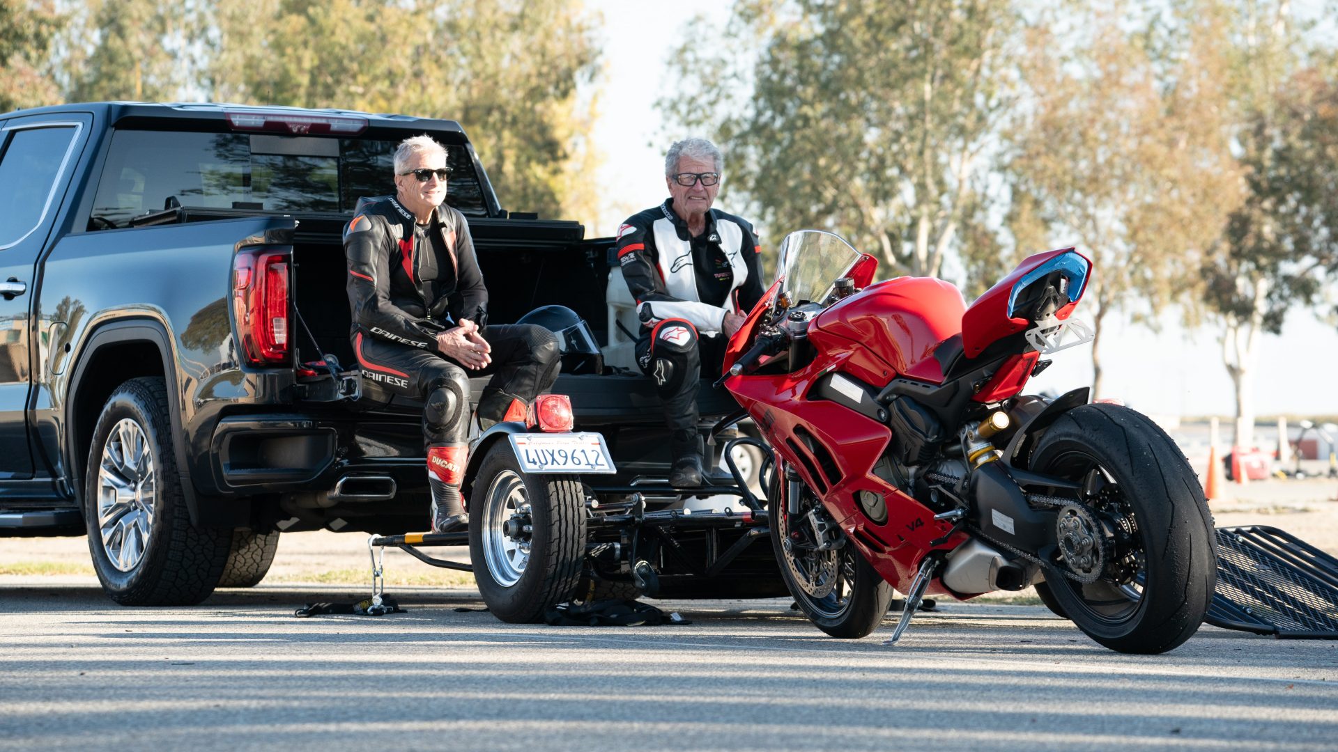 Ducati Panigale parked near two riders in leather gear at a gathering in Orange County