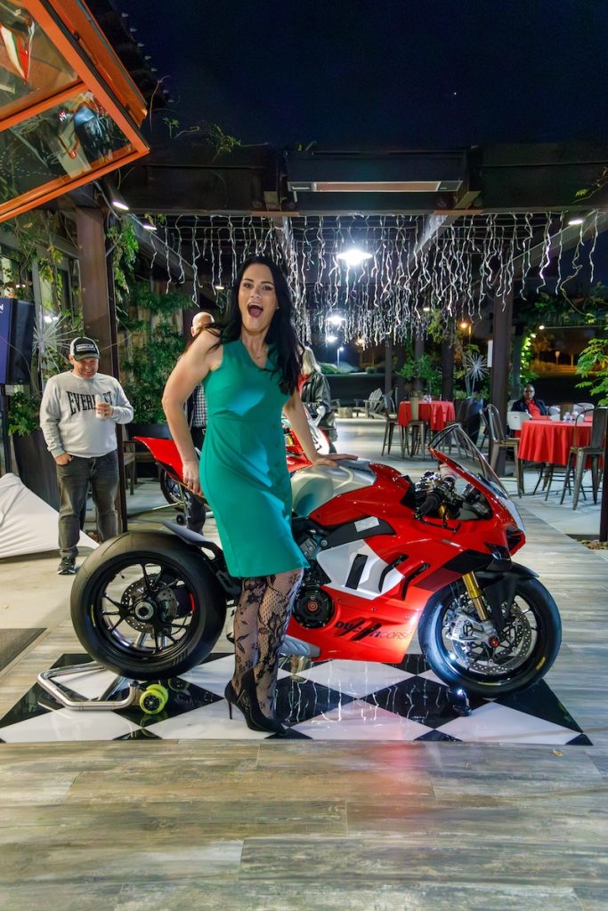 Ducati Panigale showcased at DROC 2024 Annual Holiday Party in Orange County with a smiling rider in a green dress