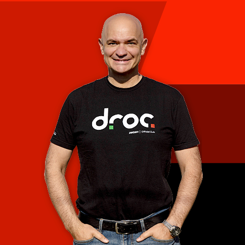 DROC team member in Ducati club shirt against a vibrant background representing Ducati culture in Orange County