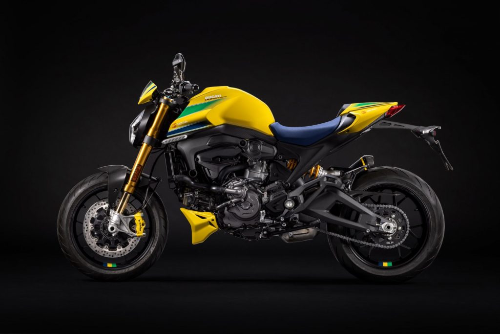 Side view of a yellow, green and blue liveried Ducati Monster motorcycle in a studio