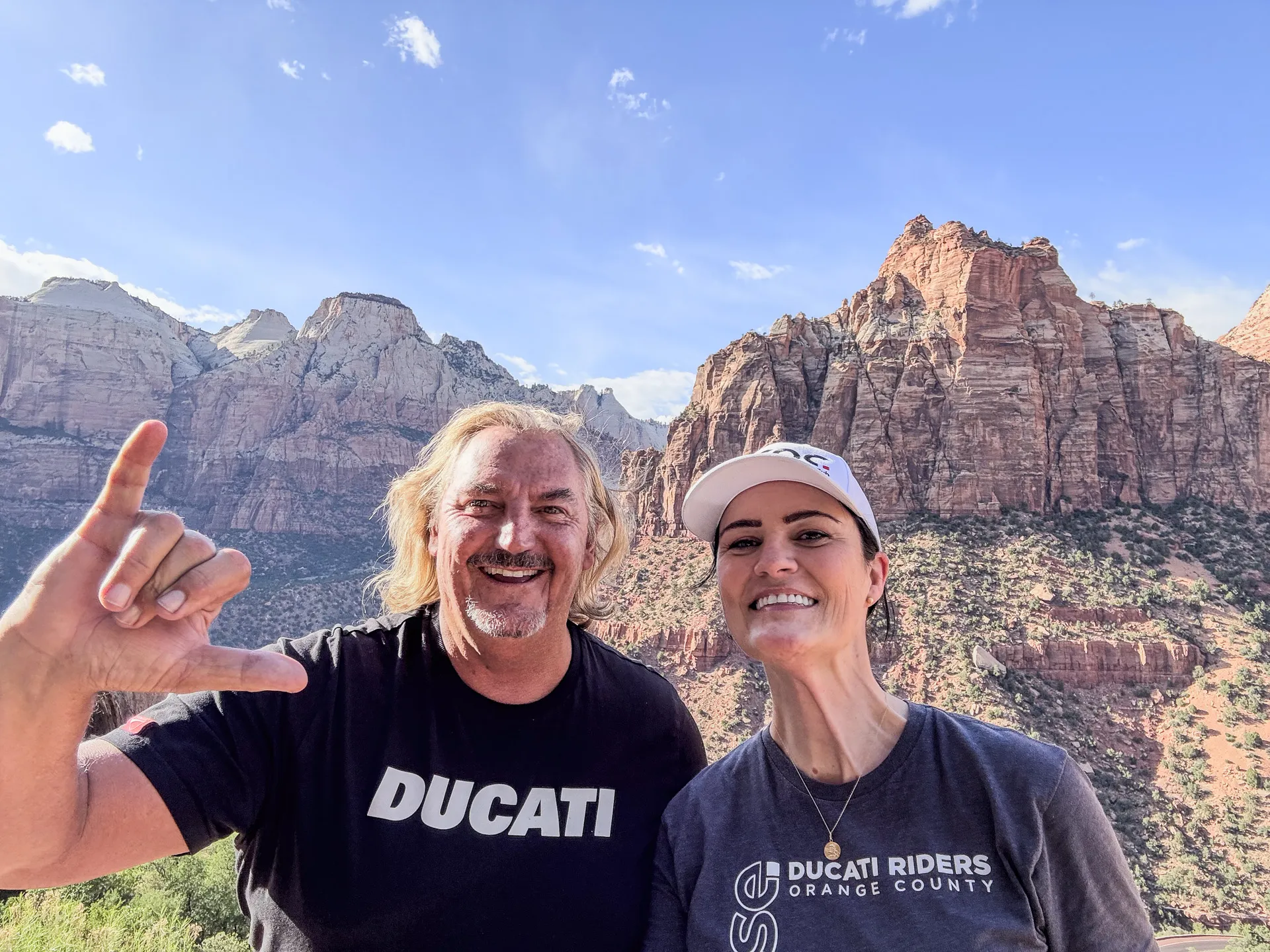 Ducati Riders of Orange County members posing with stunning mountain backdrop in Zion National Park