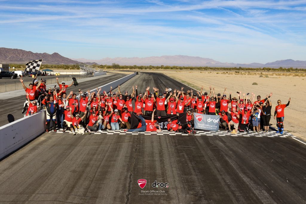 DROC track days at Chuckwalla Valley Raceway 1 Ducati riders celebrating at a track day in the desert with banners and checkered flags in Orange County