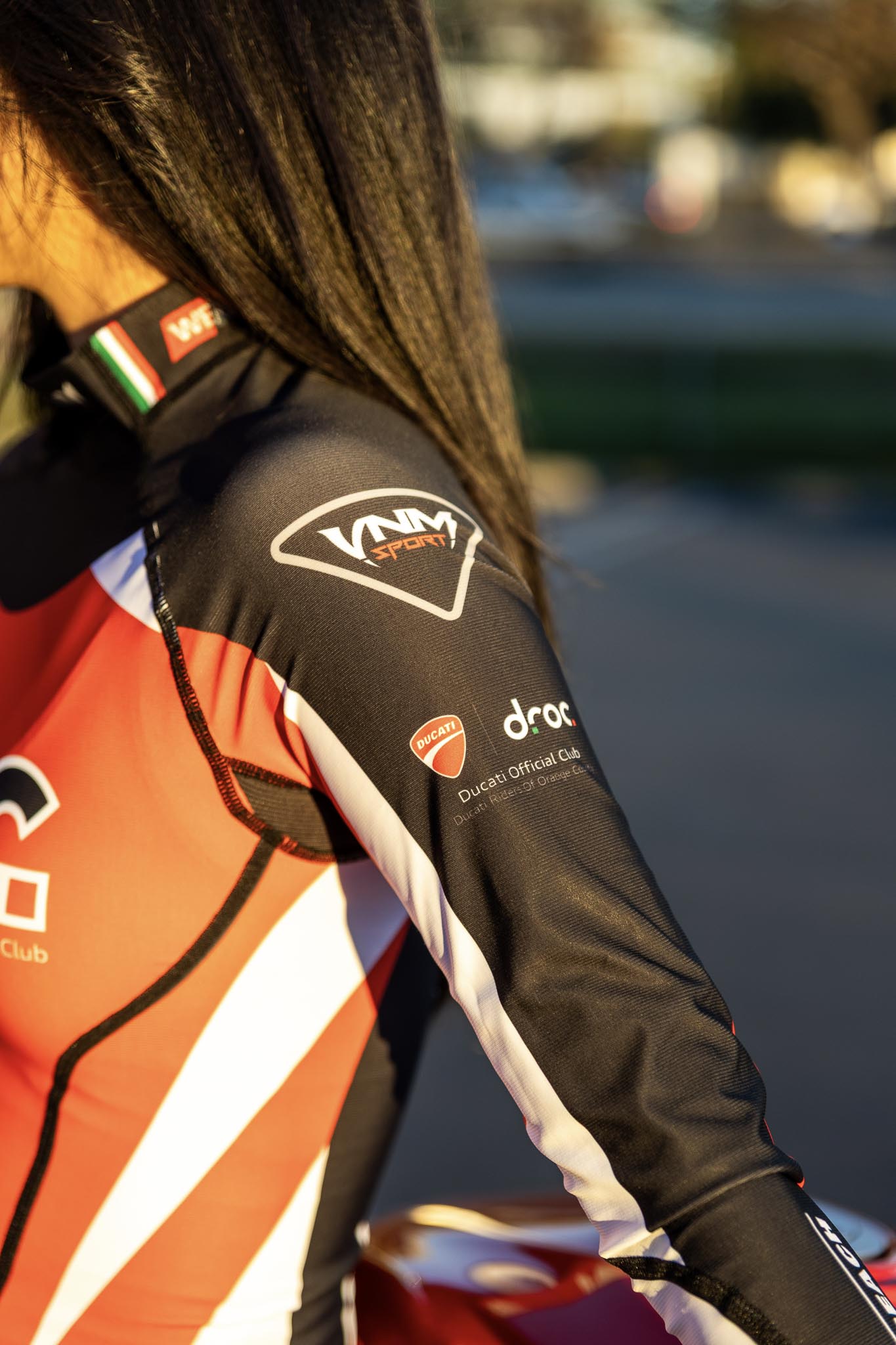 Ducati club member wearing DROC compression shirt in racing gear at sunny Orange County location