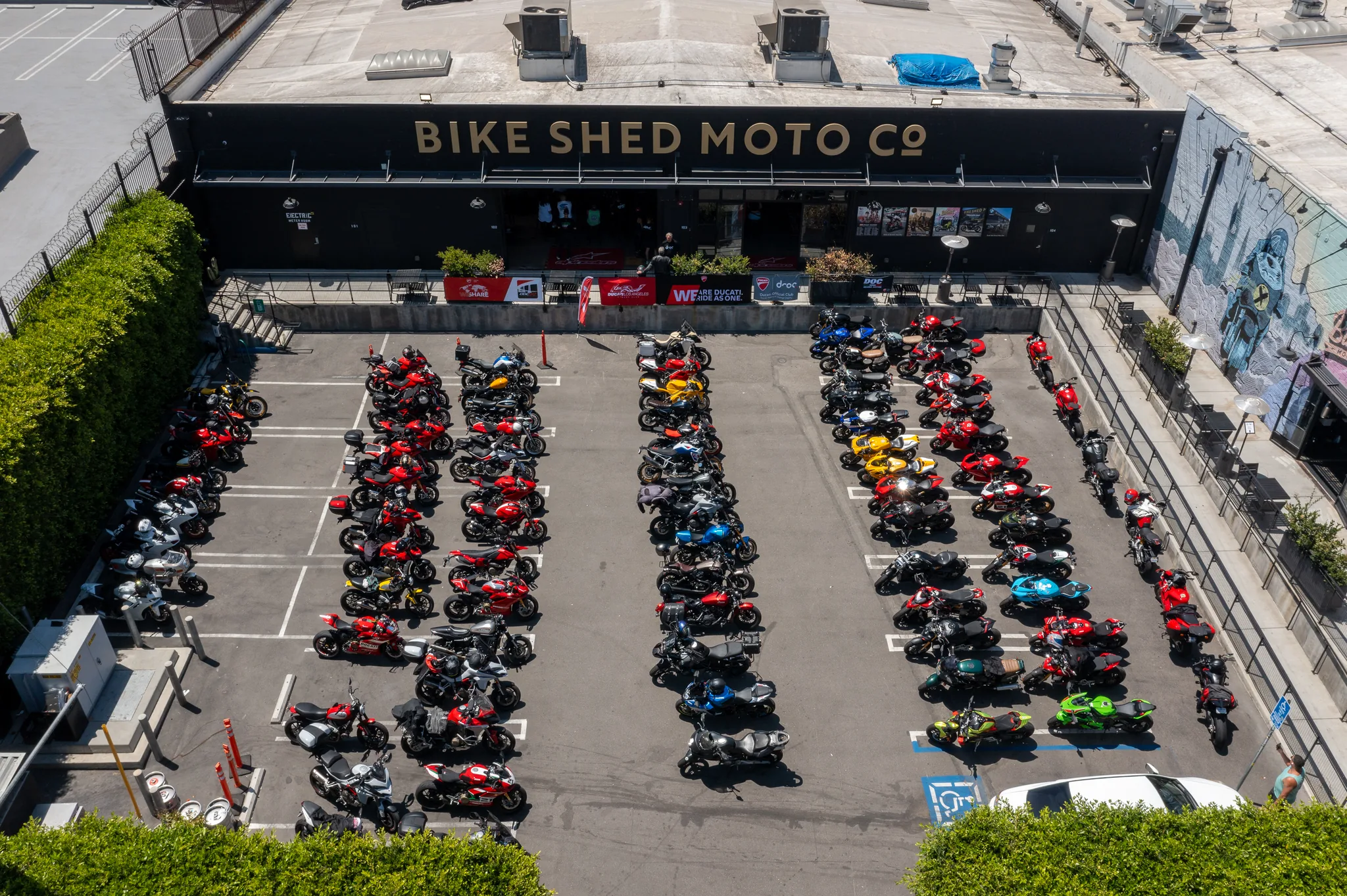 6th Street Viaduct and DTLA rides 2 Aerial view of rows of Ducatis filling the Bike Shed Moto Co forecourt on Industrial Street in the Los Angeles Arts District
