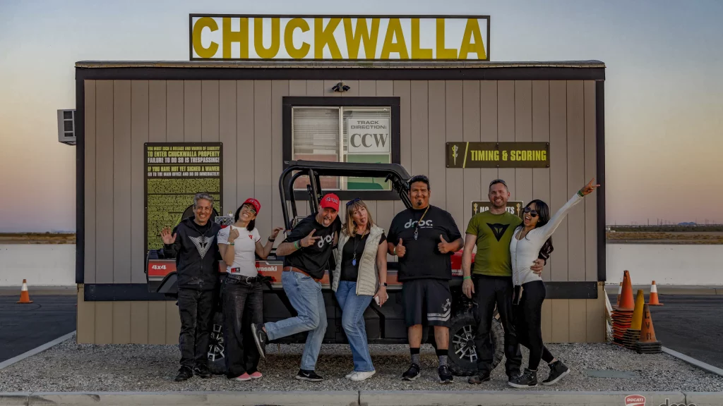 Ride with DROC: the six ways we ride 12 Seven people posing under the CHUCKWALLA sign on the circuit's timing and scoring building