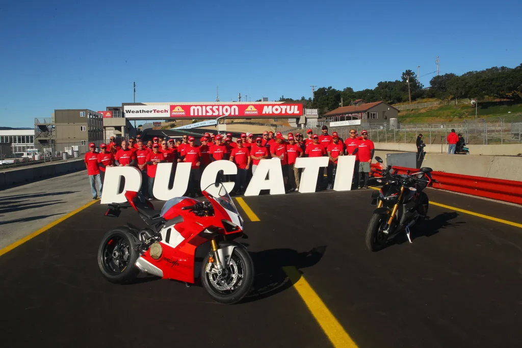 DROC at WeatherTech Raceway Laguna Seca 1 Ducati motorcycles at a track day with a group of riders in red shirts at a racetrack celebrating their passion