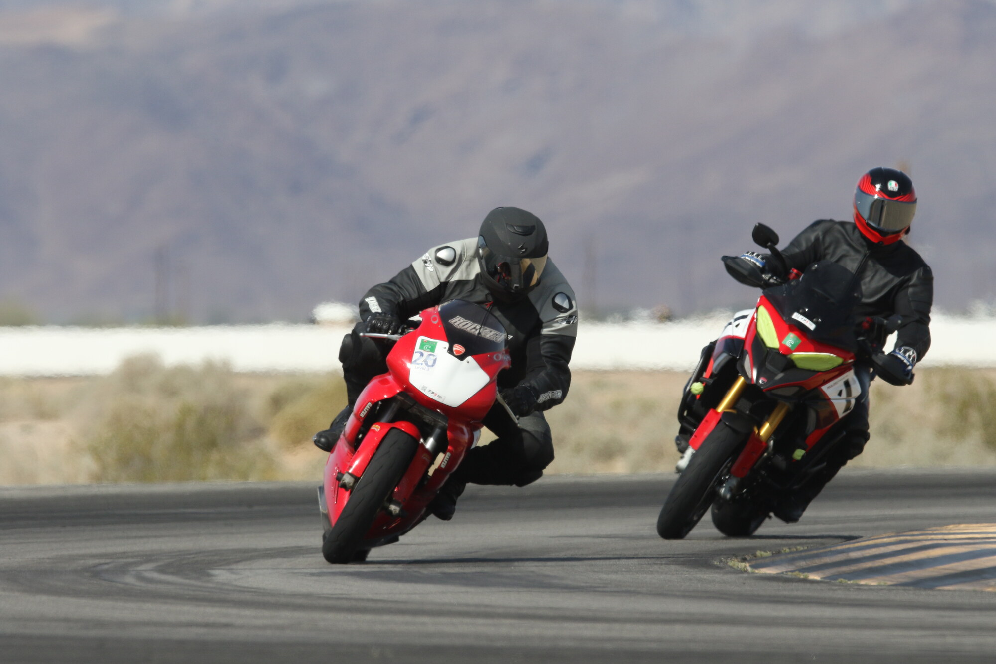 Patrick Pallan, left, on his red and white Ducati cornering alongside another DROC rider at Chuckwalla Valley Raceway