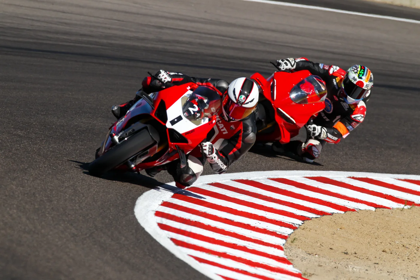 Two DROC riders nose to tail over the kerbing at a Laguna Seca Ducati track day