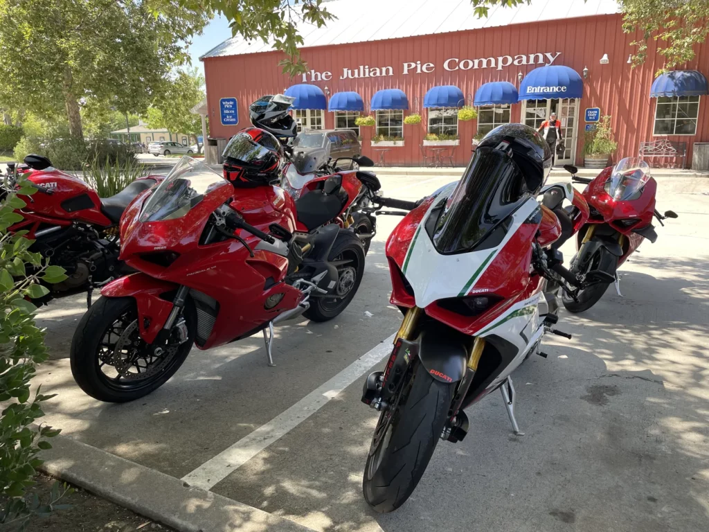 Five red sport bikes parked in front of The Julian Pie Company building with blue awnings and a person exiting