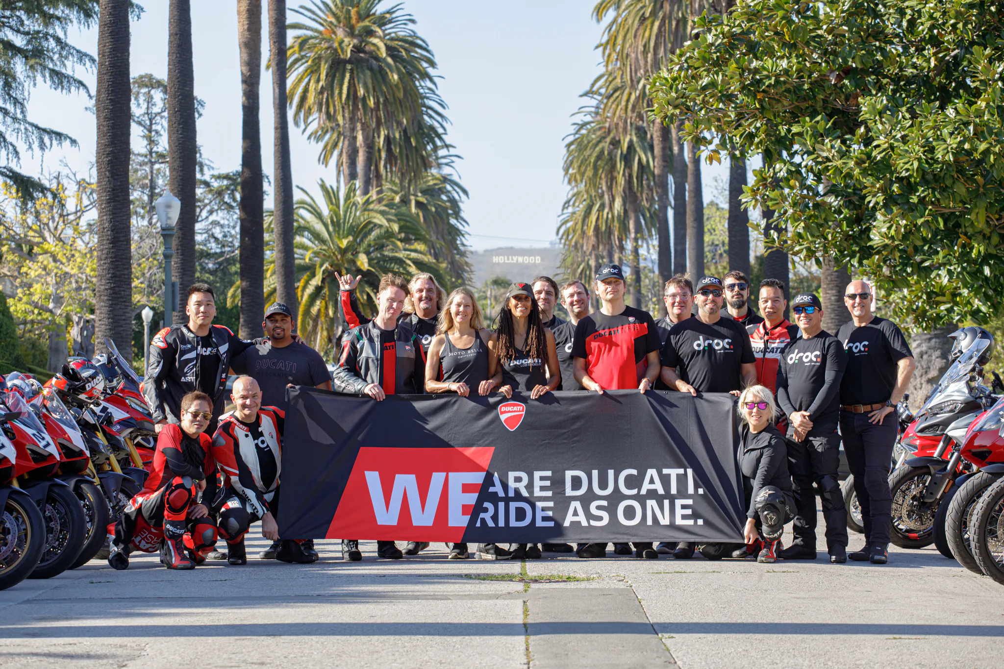 6th Street Viaduct and DTLA rides 6 DROC riders with a club banner on a palm-lined Beverly Hills boulevard, their Ducatis parked behind them