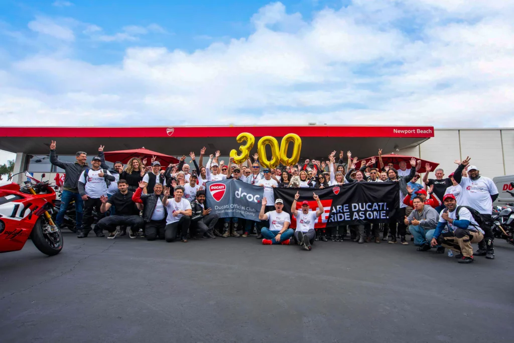 Ride with DROC: the six ways we ride 22 Crowd outside the Newport Beach dealership with gold 300 balloons and a DROC banner