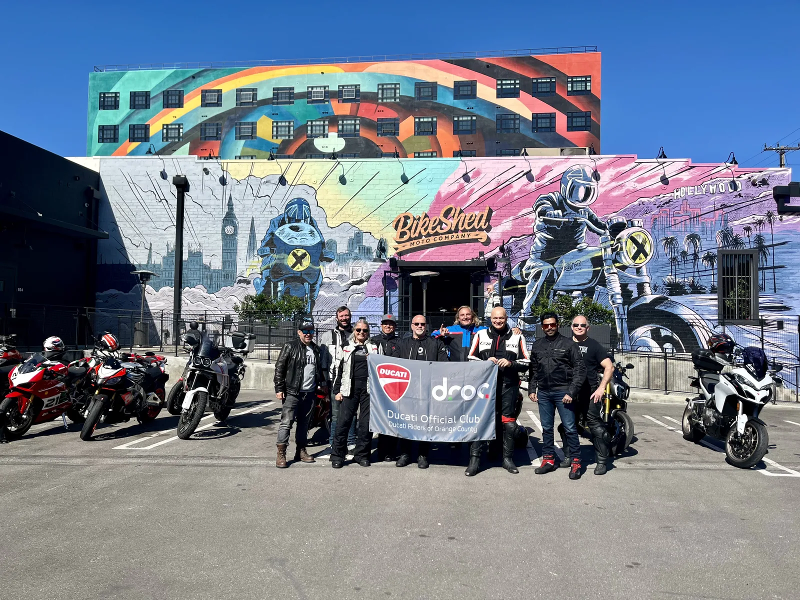 DROC Rules of Conduct 1 DROC members stand with their club banner and motorcycles in front of the colorful Bike Shed mural in Los Angeles, April 2024